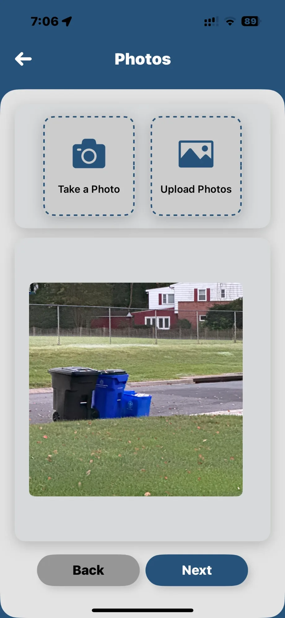 App de ARGUS: el paso de fotos de un reporte nuevo, con los botones de hacer foto o subirla y la imagen de unos cubos dejados en la acera ya adjunta.